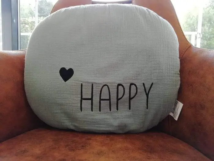 foto van kussen op stoel met happy erop